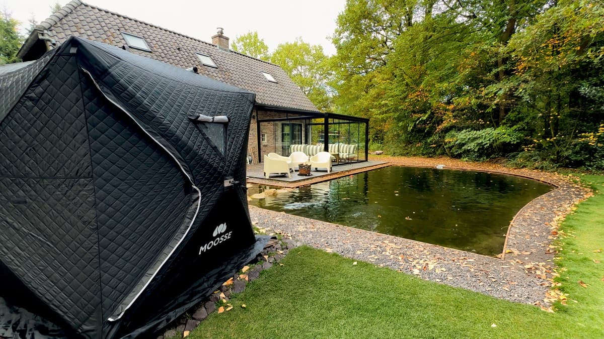 Saunatent in een tuin naast een vijver